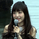 Kanda holds a microphone and talks to the press.